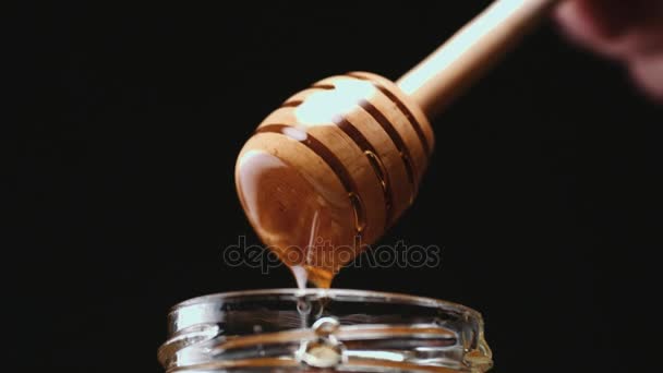 Persona sumergiendo palo de miel en la miel — Vídeo de stock