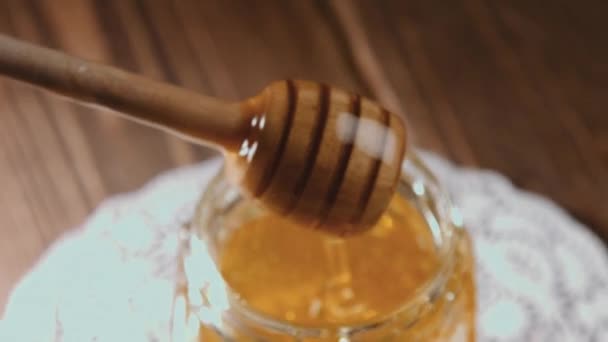 Людина занурює медову паличку в мед — стокове відео