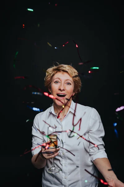 Mujer alegre con champán en confeti — Foto de Stock