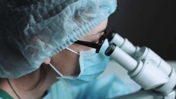 Female scientist looking through microscope — Stock Video