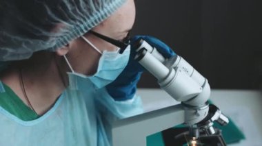 Mikroskopla laboratuvarda çalışan bilim adamı