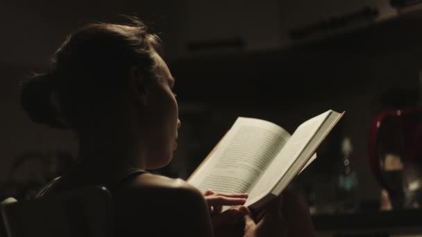 Woman read book in the kitchen. — Stock Video