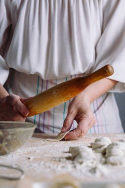 Ahşap oklava ile et hamur tatlısı yapma.