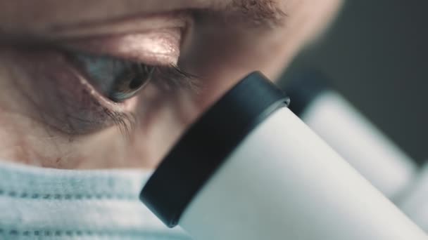 Female scientist looking through microscope — Stock Video