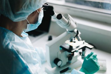 Mikroskopla laboratuvarda çalışan bilim adamı