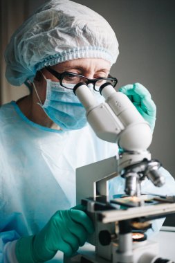 Mikroskopla laboratuvarda çalışan bilim adamı