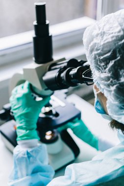 Mikroskopla laboratuvarda çalışan bilim adamı