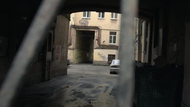 De achtertuin van een flatgebouw door de tralies — Stockvideo