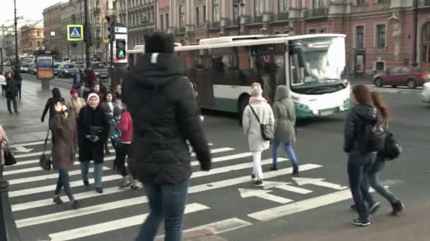 Groep mensen de rijbanen bij een zebrapad oversteken. — Stockvideo