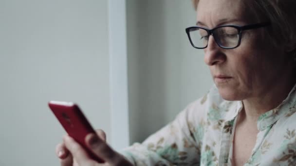 Mujer viendo algo en la pantalla del teléfono inteligente — Vídeos de Stock