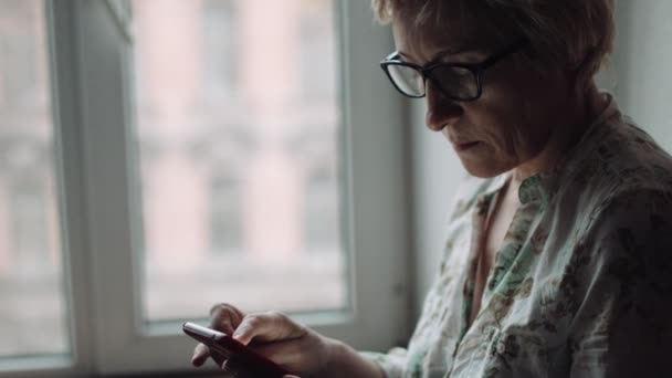 Femme regardant quelque chose sur l'écran du smartphone — Video