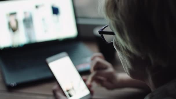 Женщина смотрит что-то на экране смартфона — стоковое видео