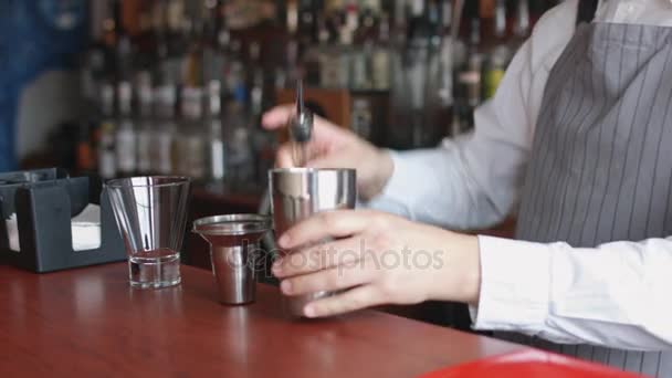 Бармен наливает розовый коктейль из шейкера — стоковое видео