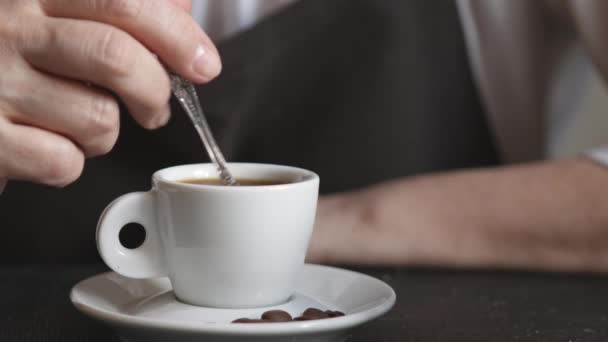 Woman in the apron stir the sugar in small cup of hot coffee. — Stock Video