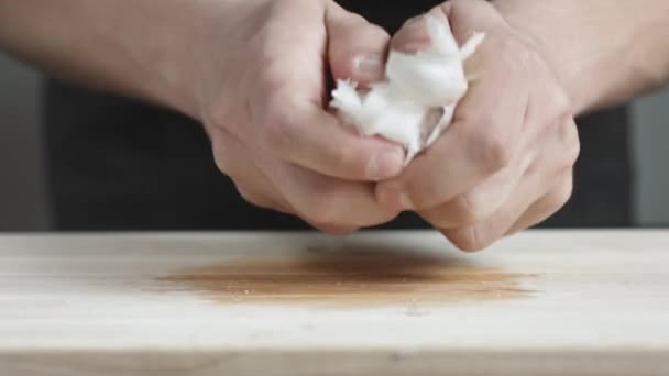 Vista frontal del hombre yong cocinero limpia una cabeza de ajo de la tabla de cortar la cáscara . — Vídeos de Stock