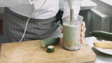 Yeşil smoothie hazırlık üniformalı genç yemek
