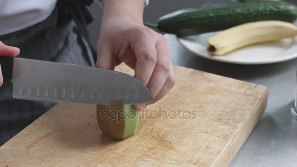 Jovem cozinheiro em uniforme preparando smoothie vegetal — Vídeo de Stock