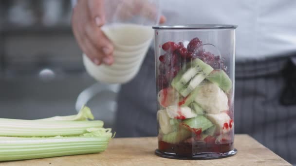 Jonge koken in uniform voorbereiding smoothie — Stockvideo