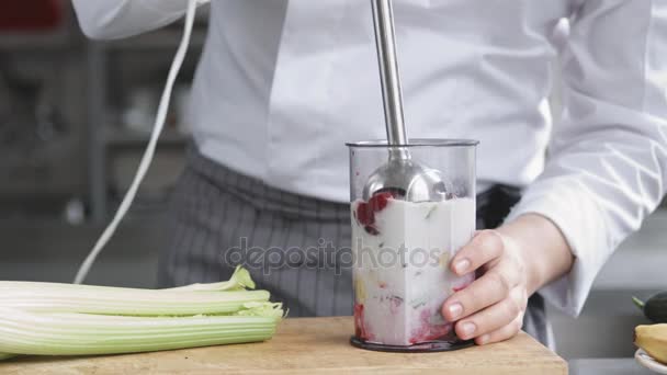 Jovem cozinheiro em uniforme de preparação smoothie — Vídeo de Stock