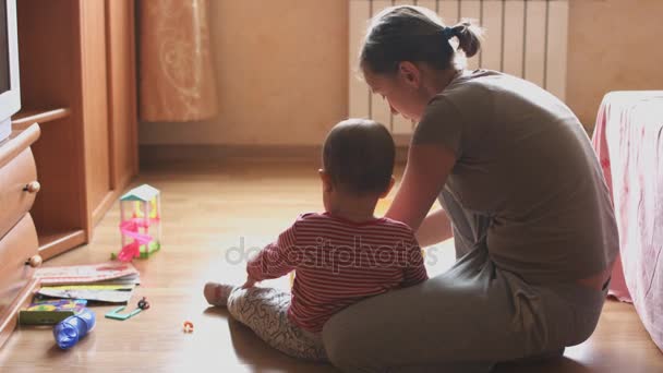 Madre e hijo jugando en la habitación sentados en el suelo . — Vídeos de Stock