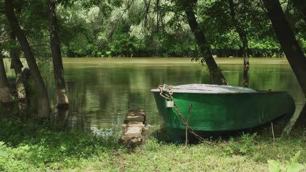 Oude vissersboot aan de oever van de kalme rivier — Stockvideo