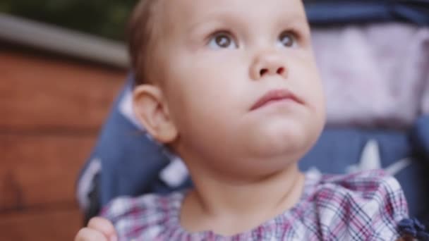 Dziecko zje pączka na ulicy — Wideo stockowe