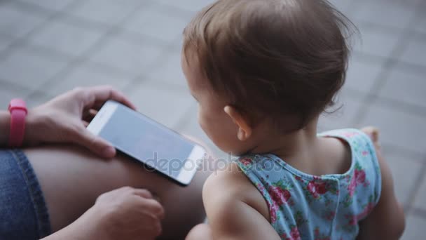 Дитина дивиться щось на смартфон — стокове відео