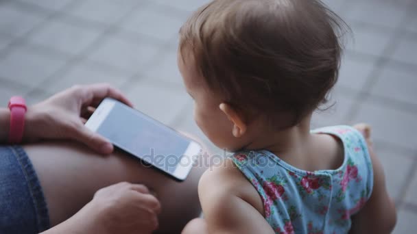 Criança está assistindo algo no smartphone — Vídeo de Stock