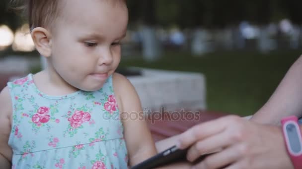 Criança está assistindo algo no smartphone — Vídeo de Stock