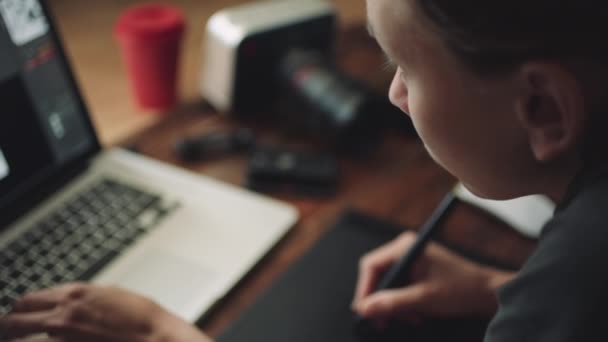 Vrouw ontwerper werkt op een laptop met een grafische tablet. — Stockvideo