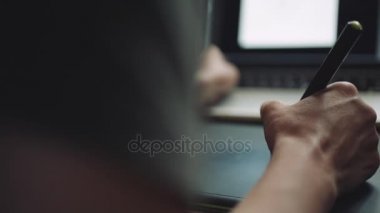 Grafik tabletli bir dizüstü bilgisayarda çalışan kadın tasarımcı.