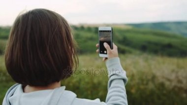 Kadın güzel bir manzara kamera telefonlarında alır..