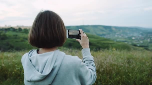 Vrouw vindt een prachtig landschap op mobiele telefoons met camera. — Stockvideo