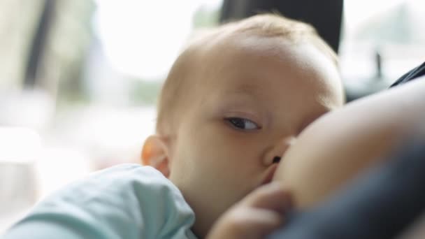 Kvinna föder sitt barn som sitter i bilen. — Stockvideo