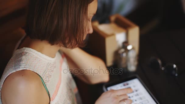 Mujer usando tableta en la cafetería — Vídeos de Stock