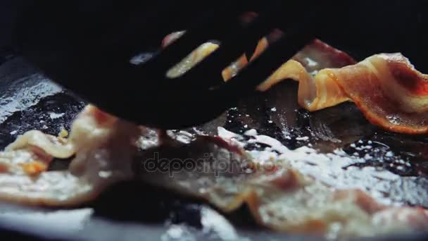 Lame corrige une tranche de bacon sur la surface de la casserole . — Video