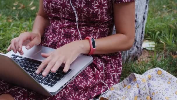 Kvinna som arbetar på gräs med laptop. — Stockvideo