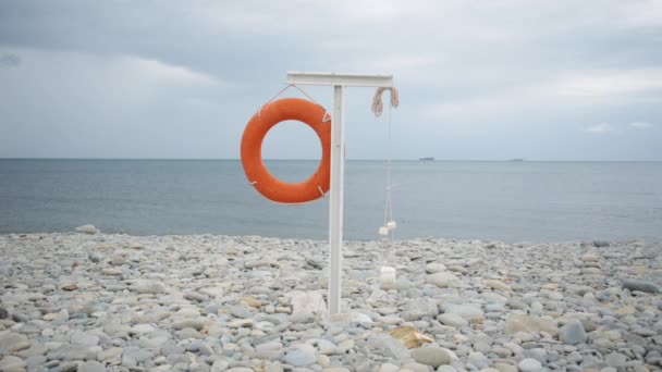 Bouée de sauvetage suspendue sur la plage vide . — Video