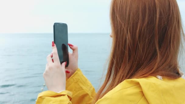 여자는 전화 카메라에 아름 다운 바다 경치를 걸립니다.. — 비디오