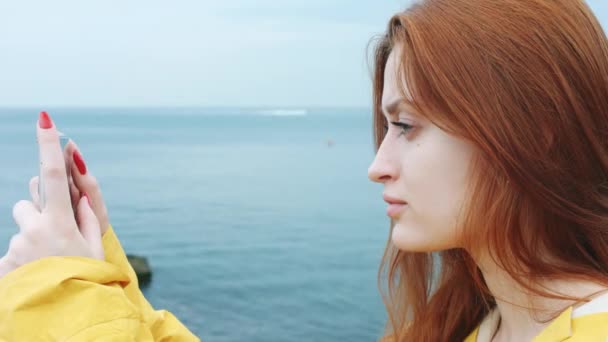 Femme prend un beau paysage marin sur une caméra téléphonique . — Video