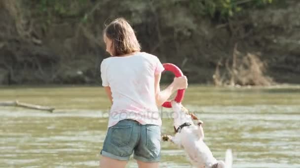 Mujer jugando con perro cerca del río — Vídeos de Stock