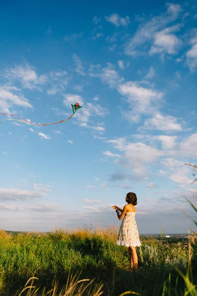 Дівчина грає з повітряним змієм у полі — стокове фото