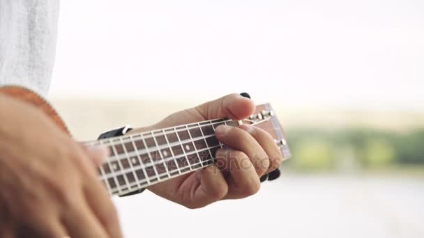 Persoon te spelen op little ukelele gitaar — Stockvideo