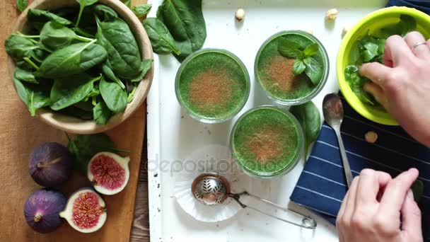 Pessoa adorna smoothies verdes folhas de hortelã fresca — Vídeo de Stock