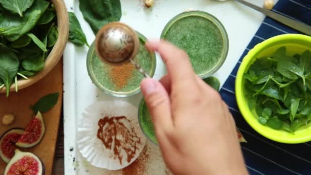 La persona adorna los batidos verdes por las hojas de la menta fresca — Vídeo de stock