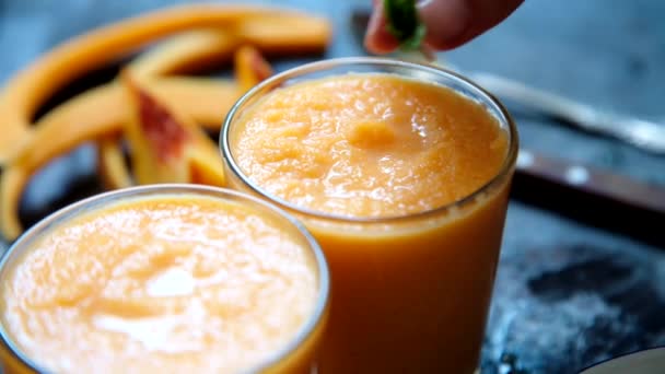 Persoon siert oranje smoothie — Stockvideo