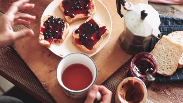 Vrouw eten boterham met pindakaas en jam. — Stockvideo