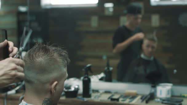 Barberaren gör snittet för en kund i barbershop. — Stockvideo