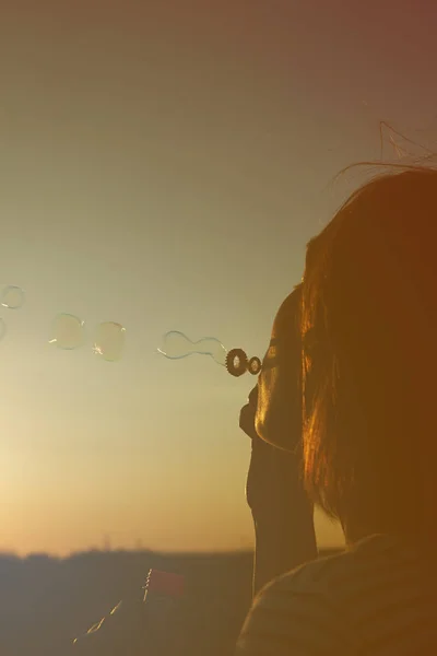 Chica infla burbujas de jabón . — Foto de Stock