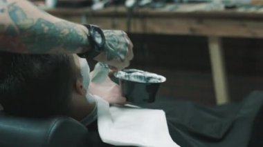 Bazı tıraş kremi bir istemcide koyarak berber.